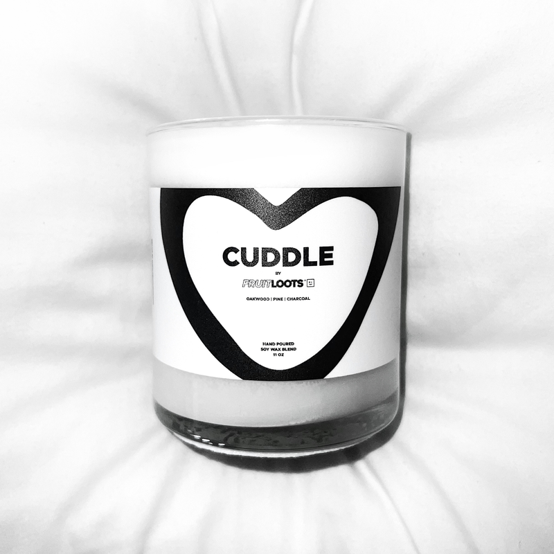 A close up of our Cuddle candle sitting in a fluffy white pillow. 